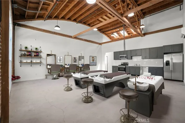 a living room with furniture kitchen view and a chandelier