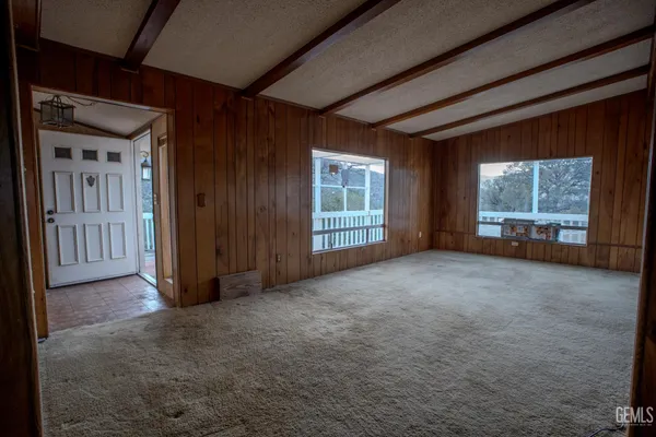 a view of an empty room with a fireplace and a window