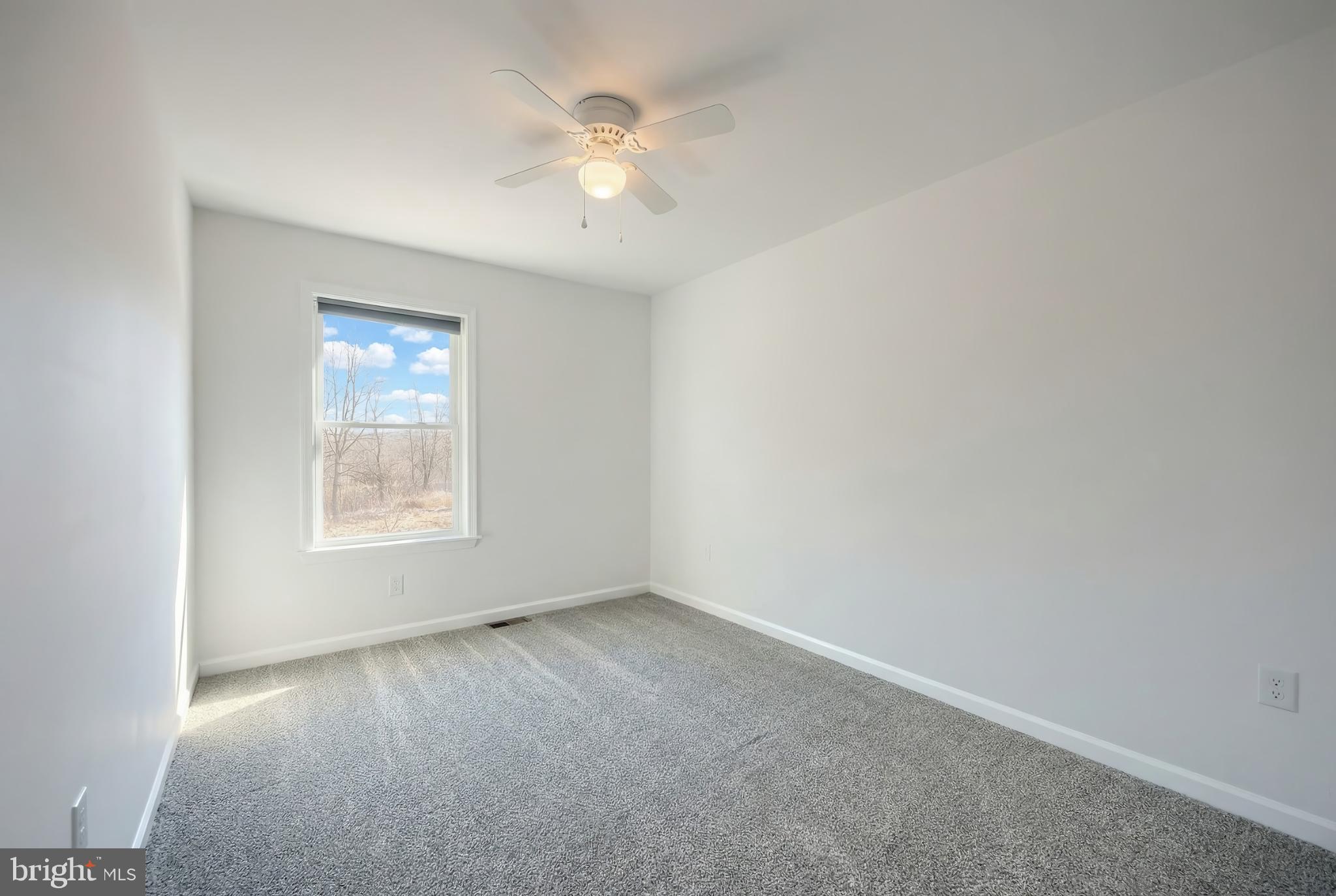 1885 Stoverstown Road, Unit 9 Spring Grove, PA 17362 - Photo 18 of 29 an empty room with a chandelier fan and windows