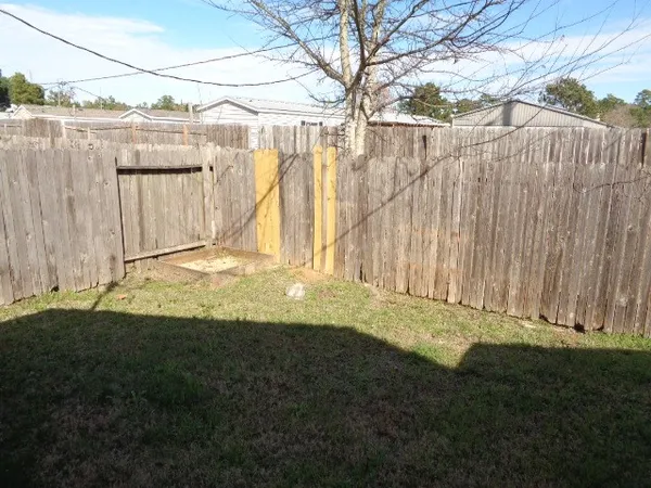 a view of a backyard with a wooden fence