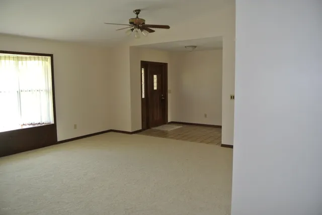 a view of a room with a ceiling fan and window