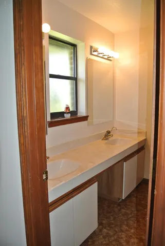a bathroom with a double vanity sink and a window