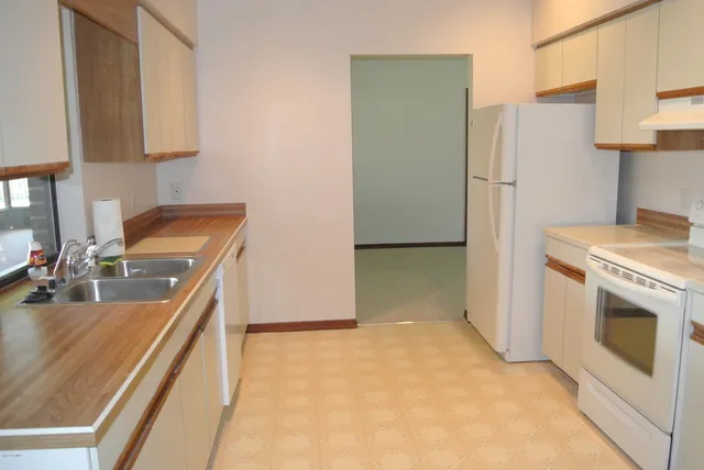 a kitchen with stainless steel appliances granite countertop a sink a stove a refrigerator a washer and dryer