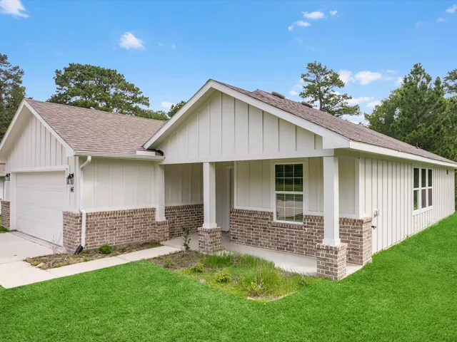 a front view of a house with a garden and yard