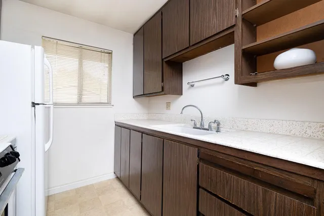 a kitchen with a sink cabinets and a window