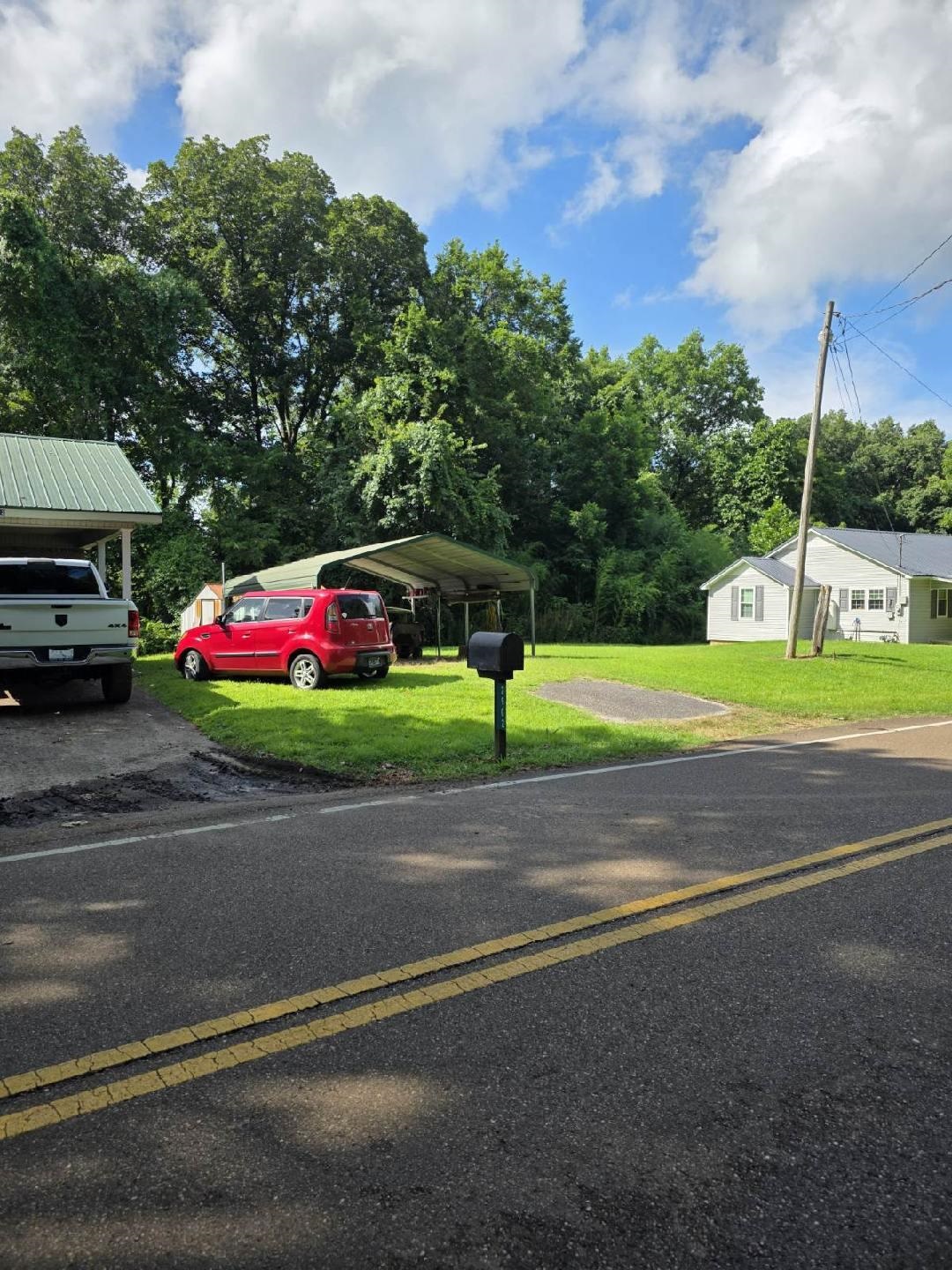View of front of property with a front lawn and a detached carport