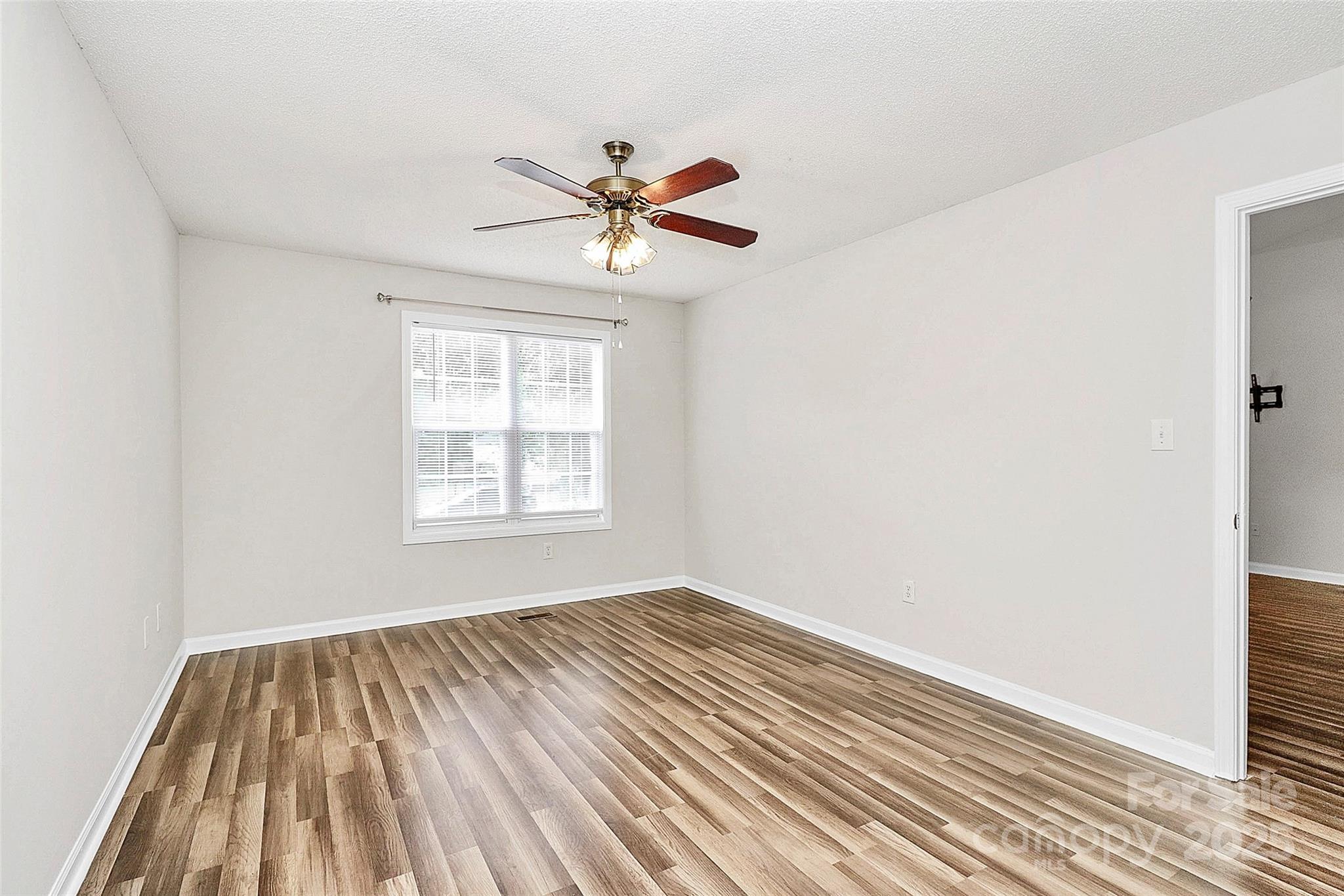 5114 Daffodil Lane Concord, NC 28025 - Photo 11 of 30 a view of empty room with wooden floor and fan