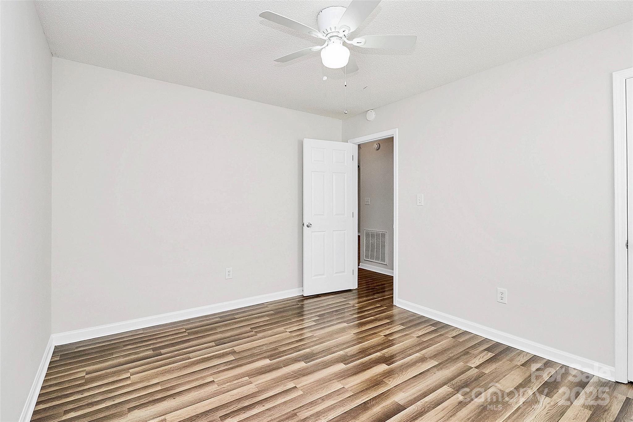 5114 Daffodil Lane Concord, NC 28025 - Photo 17 of 30 an empty room with wooden floor and fan