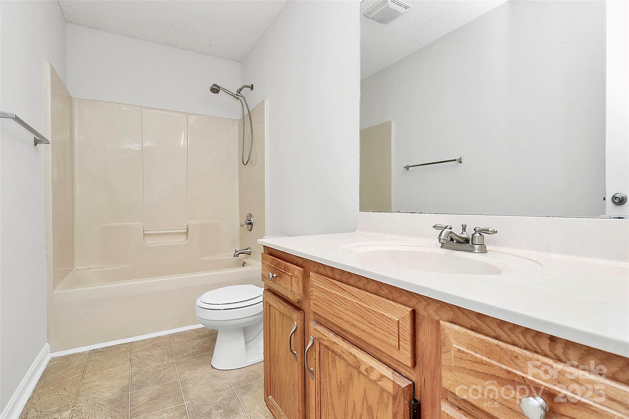 5114 Daffodil Lane Concord, NC 28025 - Photo 19 of 30 a bathroom with a granite countertop sink a toilet a mirror and bathtub
