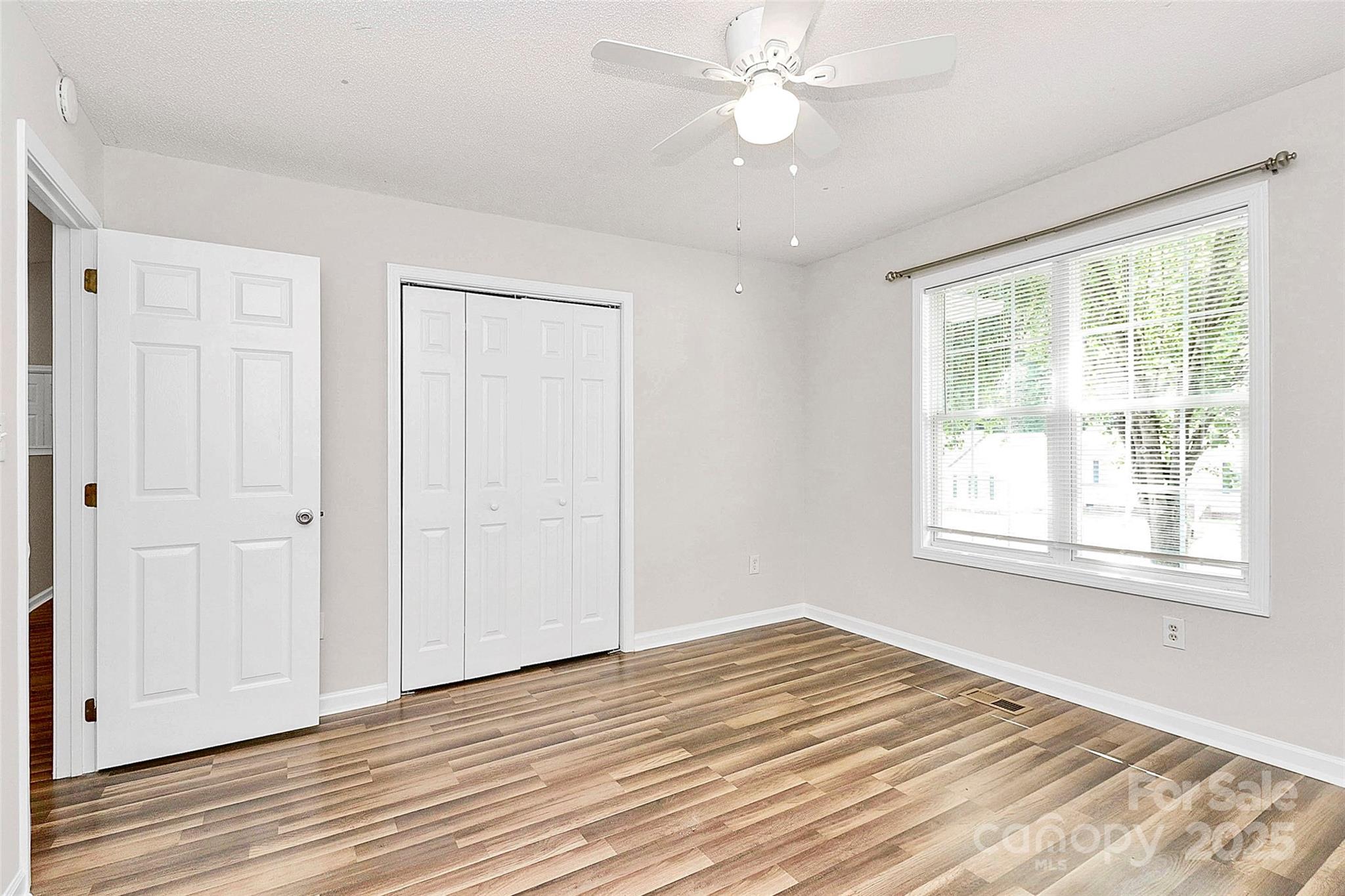 5114 Daffodil Lane Concord, NC 28025 - Photo 22 of 30 a view of empty room with wooden floor and fan
