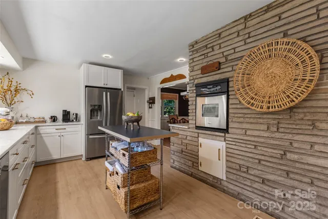 a kitchen with white cabinets and sink