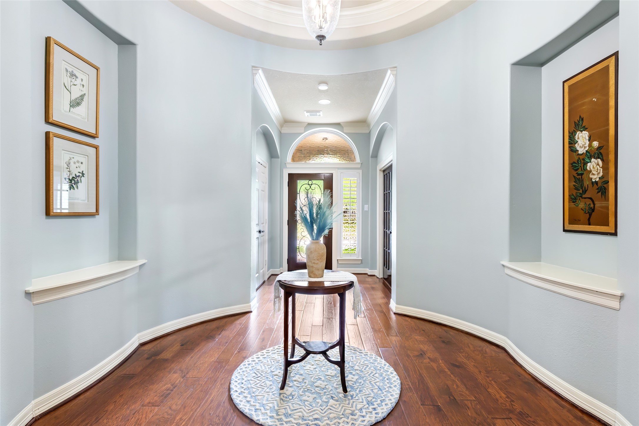 17302 Pipestone Point Court Humble, TX 77346 - Photo 3 of 50 Elegant rotunda entry with curved design, hardwood floors, and recessed shelves