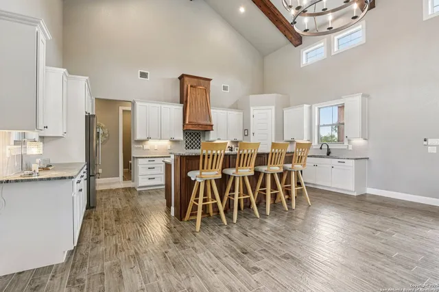a dining room with wooden floor a chandelier a wooden table and chairs