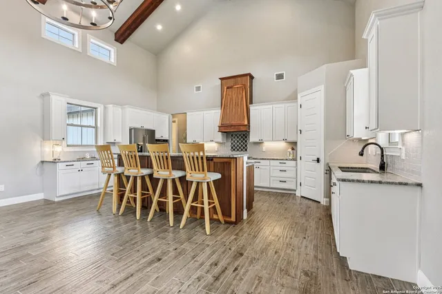 a kitchen with stainless steel appliances granite countertop a kitchen island a stove a sink a refrigerator and wooden cabinets