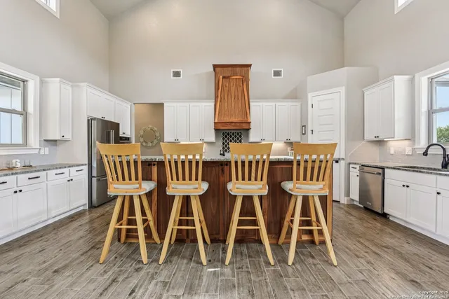 a kitchen with stainless steel appliances granite countertop a sink and cabinets