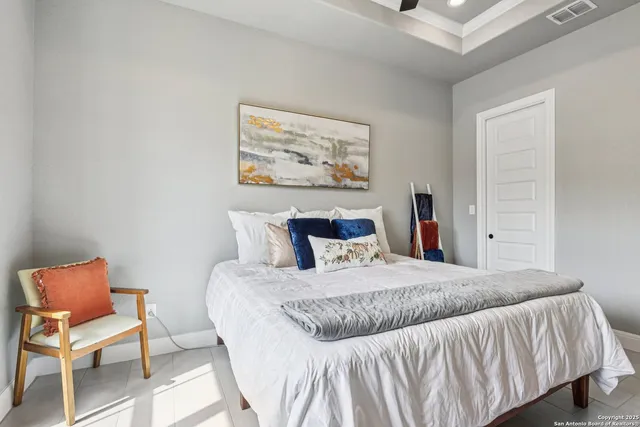 a bedroom with a bed and a rug with wooden floor