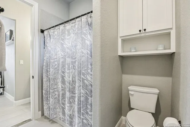 a bathroom with a shower curtain and a toilet