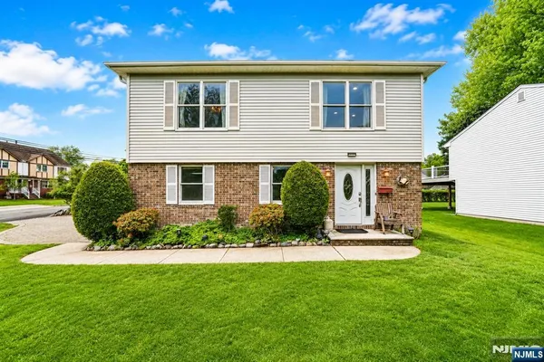 a front view of a house with a yard and outdoor seating