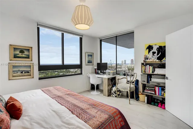 a bedroom with a bed a large window and book shelf