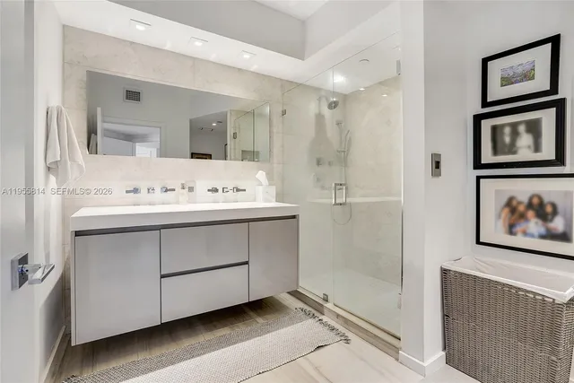 a bathroom with a sink a mirror and a shower