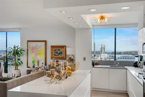 a very nice looking living room with a large window and potted plants