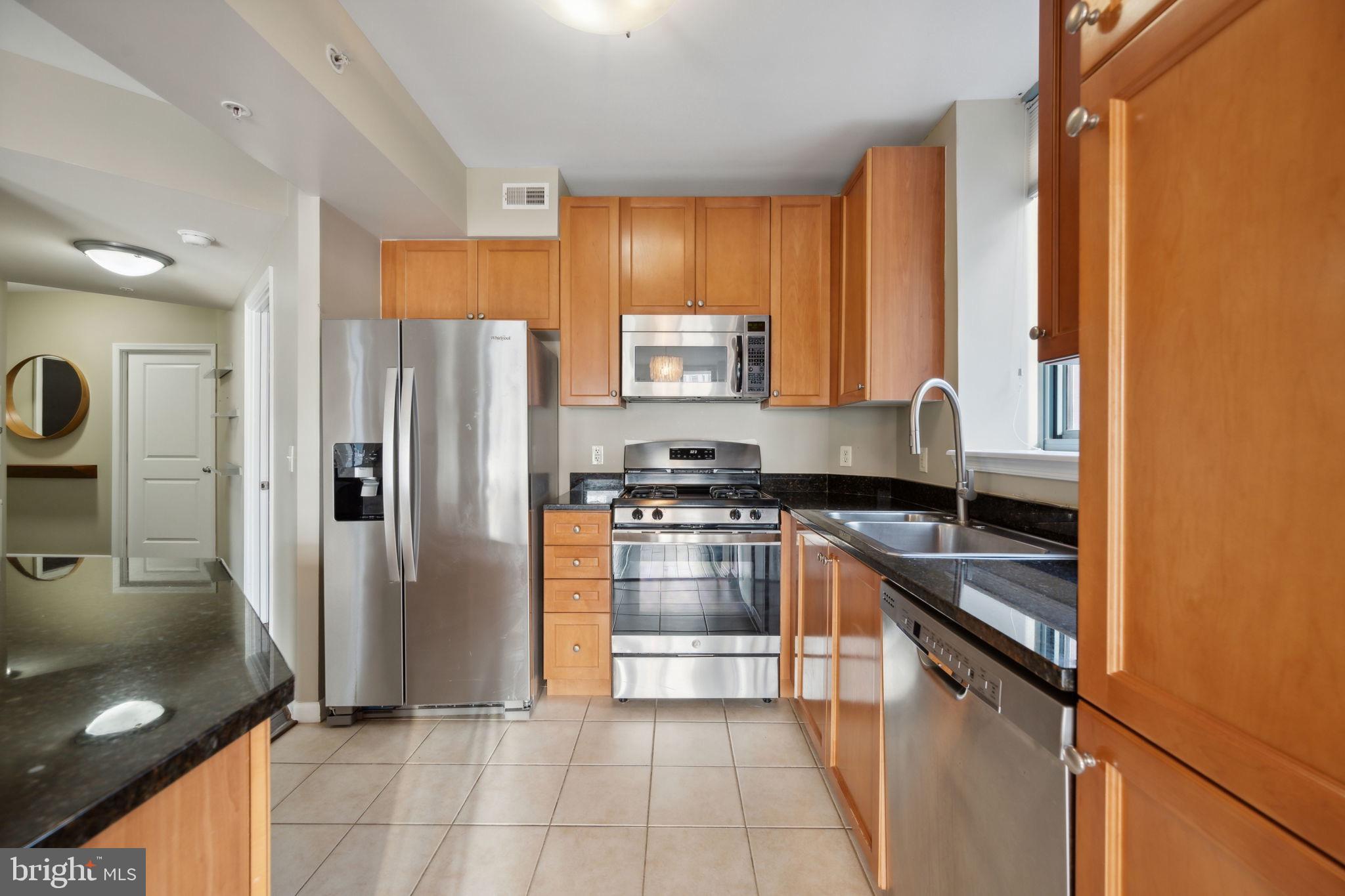 851 North Glebe Road, Unit 604 Arlington, VA 22203 - Photo 11 of 58 a kitchen with granite countertop a refrigerator and a sink