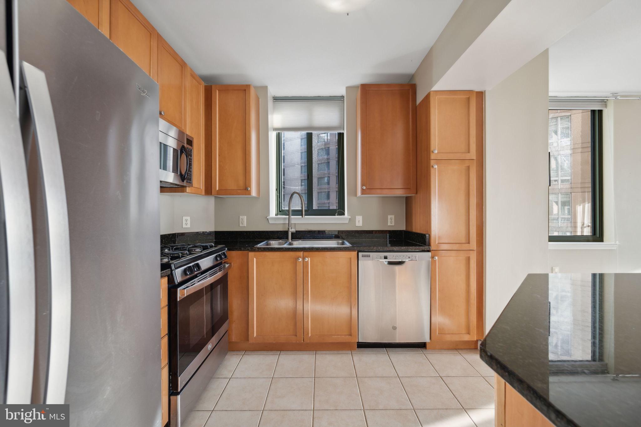 851 North Glebe Road, Unit 604 Arlington, VA 22203 - Photo 12 of 58 a kitchen with stainless steel appliances granite countertop a refrigerator and a stove top oven