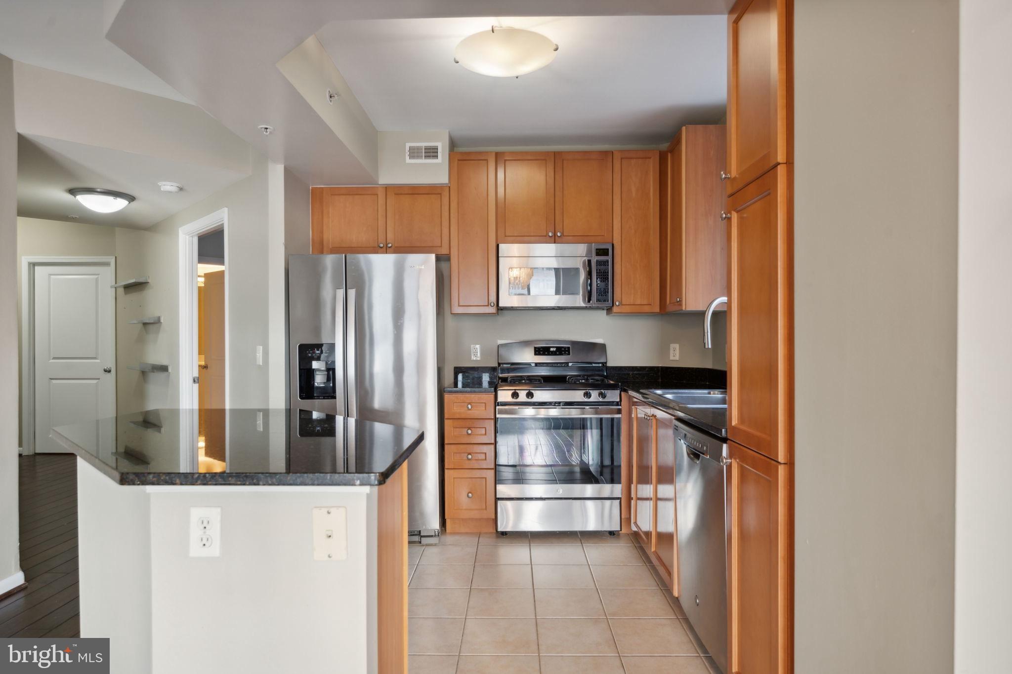 851 North Glebe Road, Unit 604 Arlington, VA 22203 - Photo 6 of 58 a kitchen with stainless steel appliances granite countertop a refrigerator and a stove