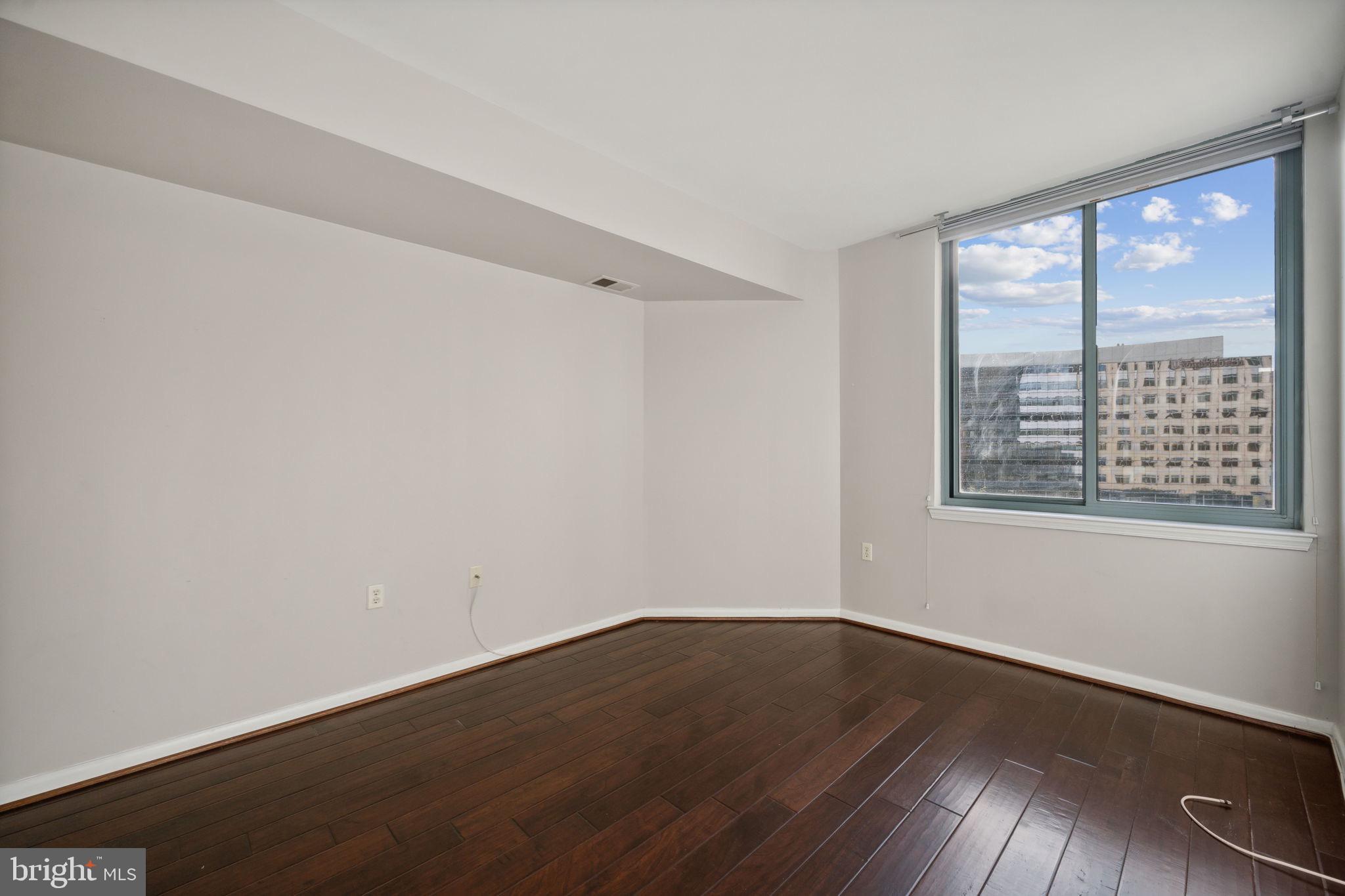 851 North Glebe Road, Unit 604 Arlington, VA 22203 - Photo 9 of 58 a view of an empty room with wooden floor and a window