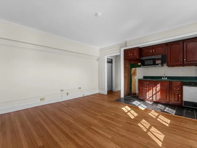 a view of empty room with wooden floor and cabinet