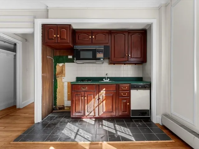 a kitchen with stainless steel appliances granite countertop a stove a microwave and a sink