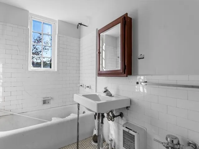 a bathroom with a tub sink and mirror
