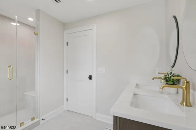 a bathroom with a toilet a sink a mirror and a window