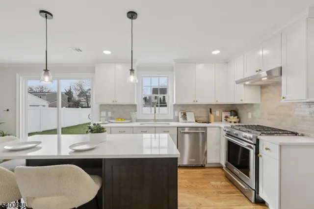 a kitchen with kitchen island a counter top space a sink stainless steel appliances and cabinets
