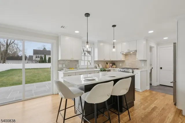 a kitchen with kitchen island a sink and a stove top oven