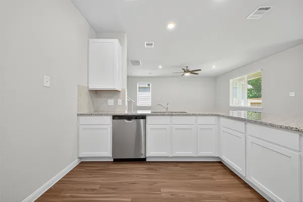 a kitchen with white cabinets and sink