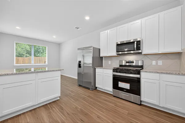 a kitchen with stainless steel appliances a stove a sink and a microwave
