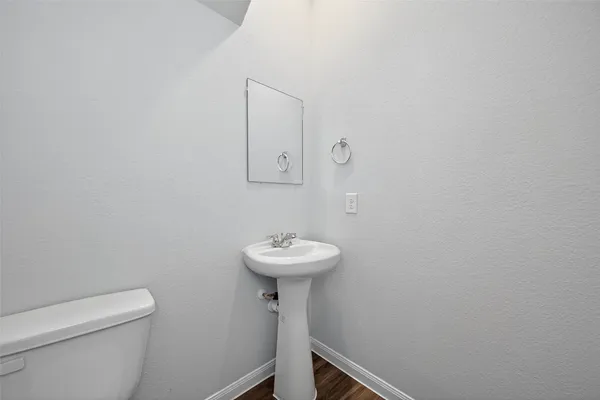 a bathroom with a sink a toilet and a mirror