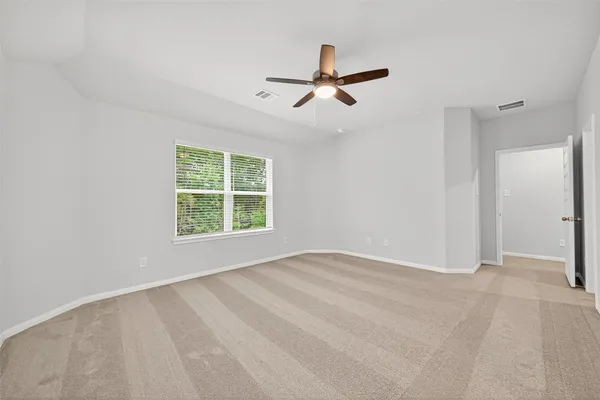 a view of empty room with windows and fan