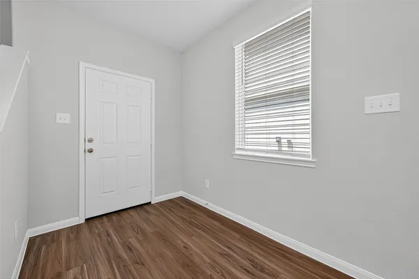 a view of a room that has wooden floor and a window