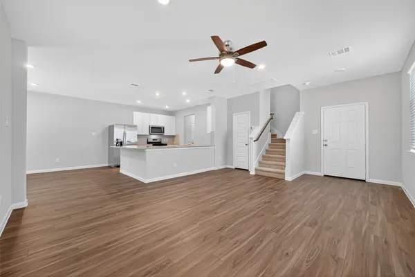 a view of a livingroom with wooden floor and staircase