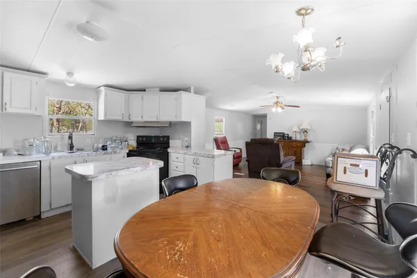 a living room with furniture a fireplace and kitchen view
