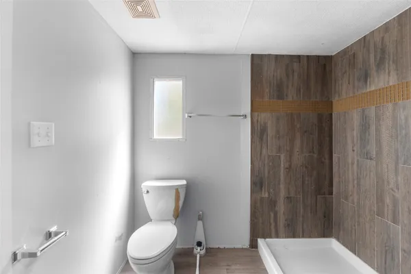 a white toilet sitting next to a bathroom sink and a shower