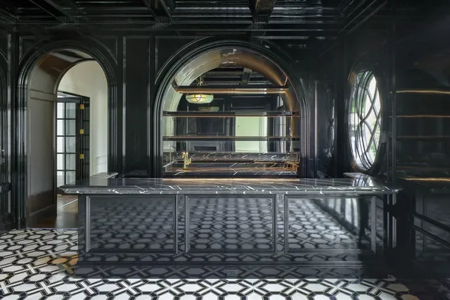 an empty room with wooden floor fireplace and windows