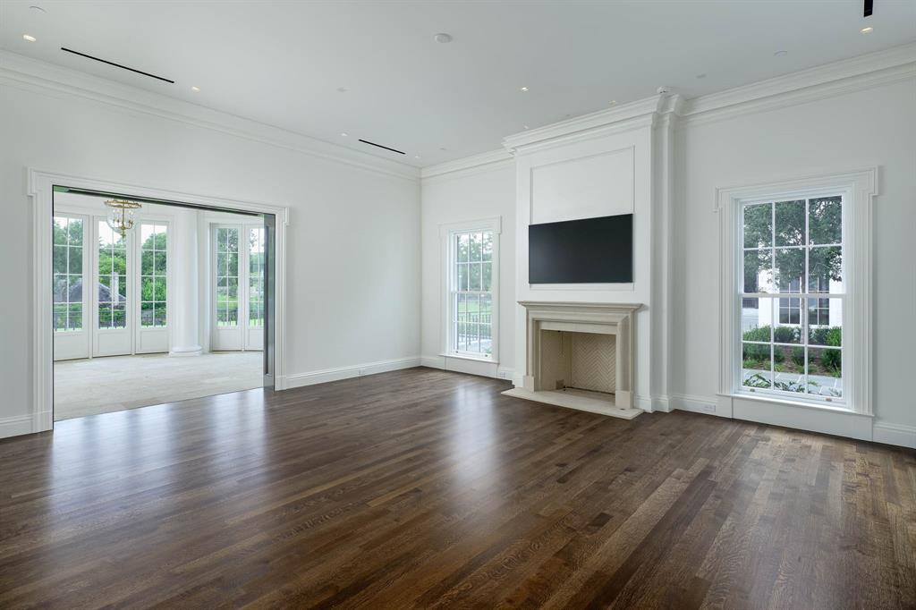 4606 Park Lane Dallas, TX 75220 - Photo 25 of 40 an empty room with wooden floor a fireplace and windows