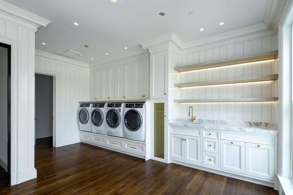4606 Park Lane Dallas, TX 75220 - Photo 33 of 40 a utility room with cabinets dryer and wooden floor