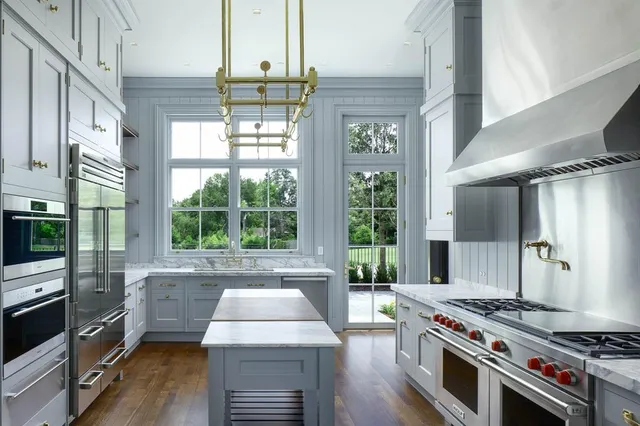 a kitchen with stainless steel appliances granite countertop a sink a microwave oven and a dining table with wooden floor