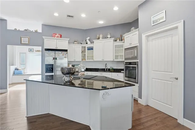 a kitchen with stainless steel appliances granite countertop a sink a stove and a refrigerator