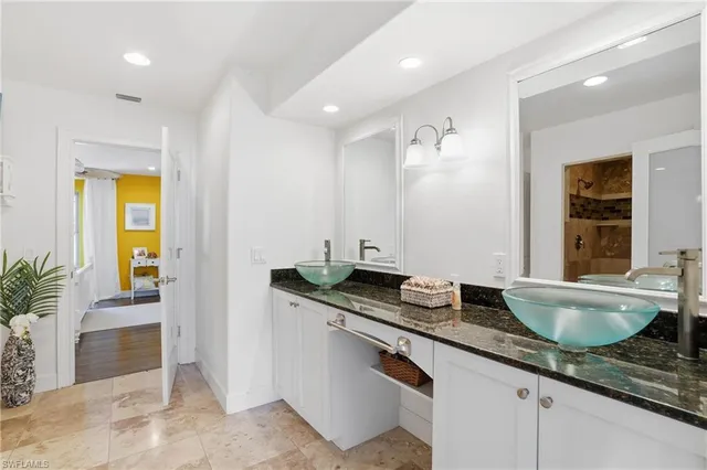 a bathroom with a granite countertop sink and a mirror