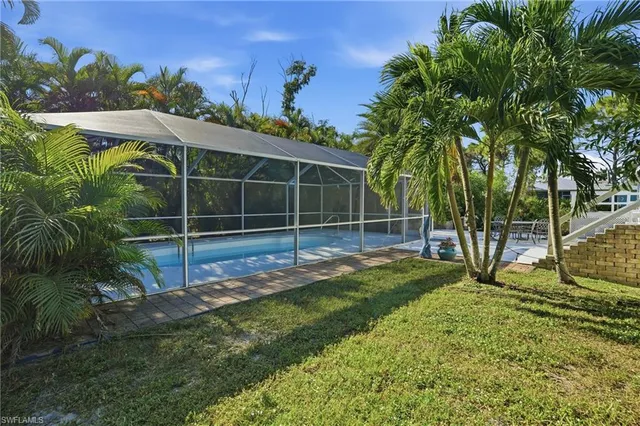 an aerial view of residential house with outdoor space and trees all around